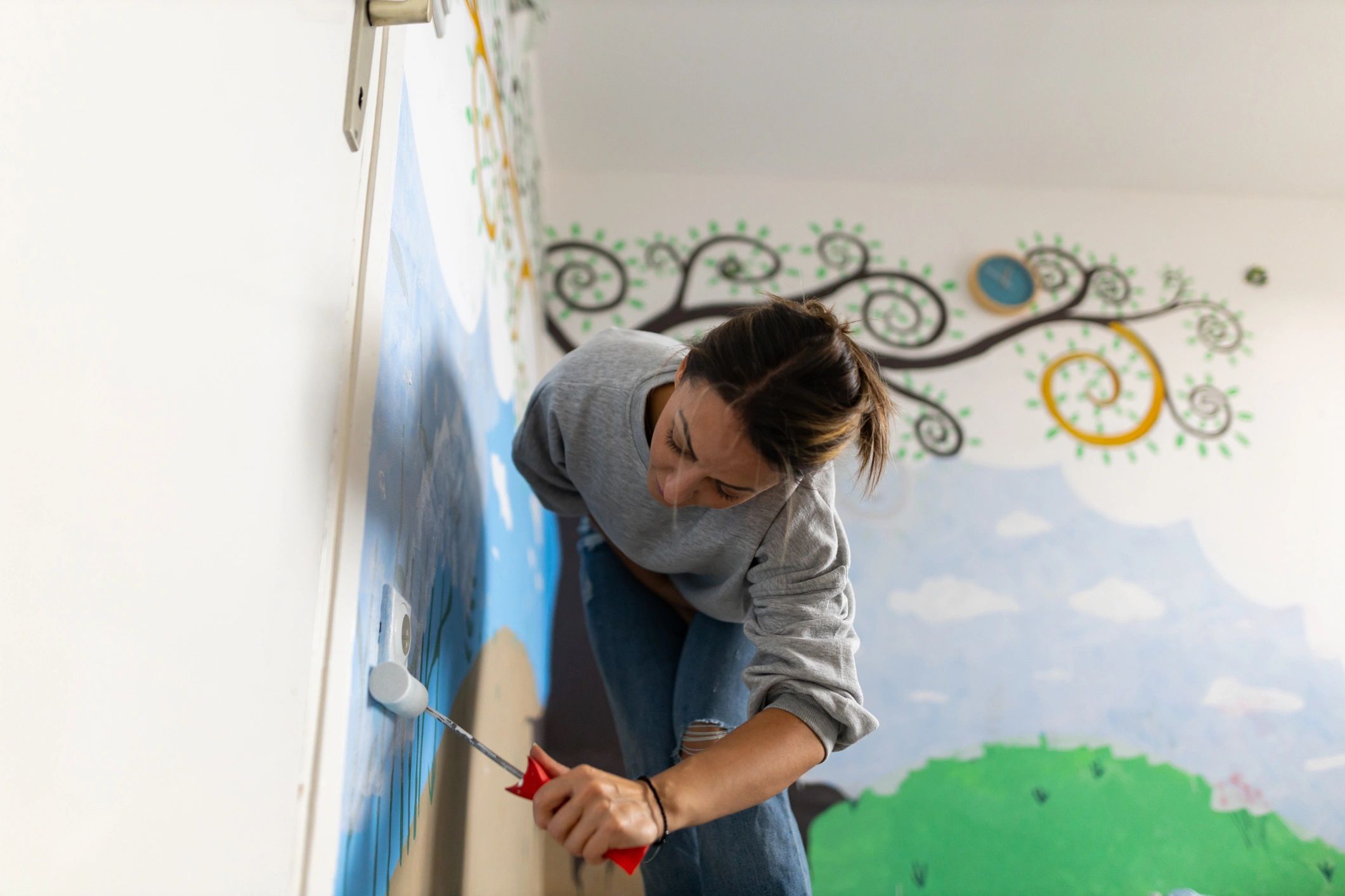 Artist painting a mural in progress