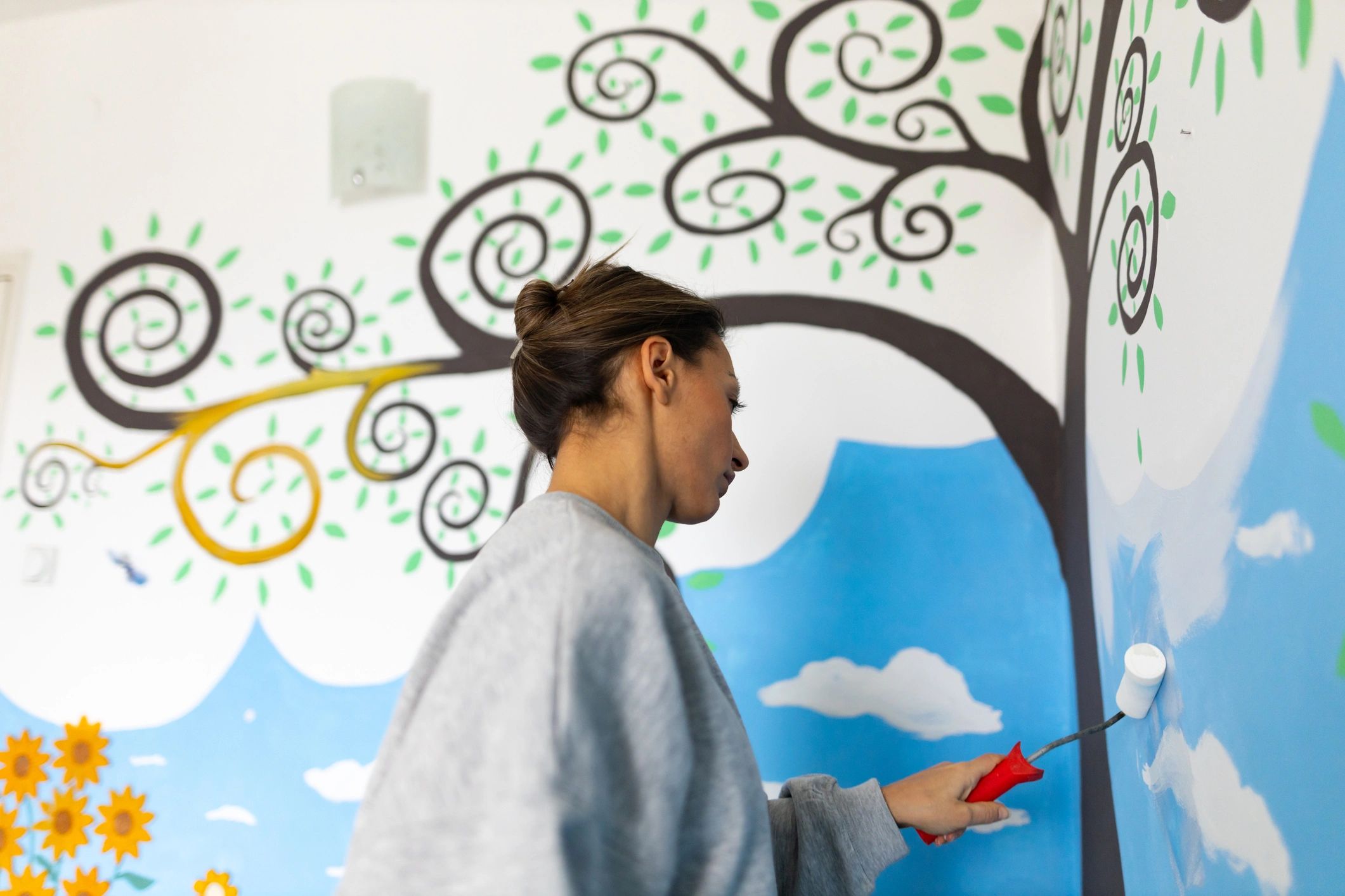 Artist painting a mural on a wall