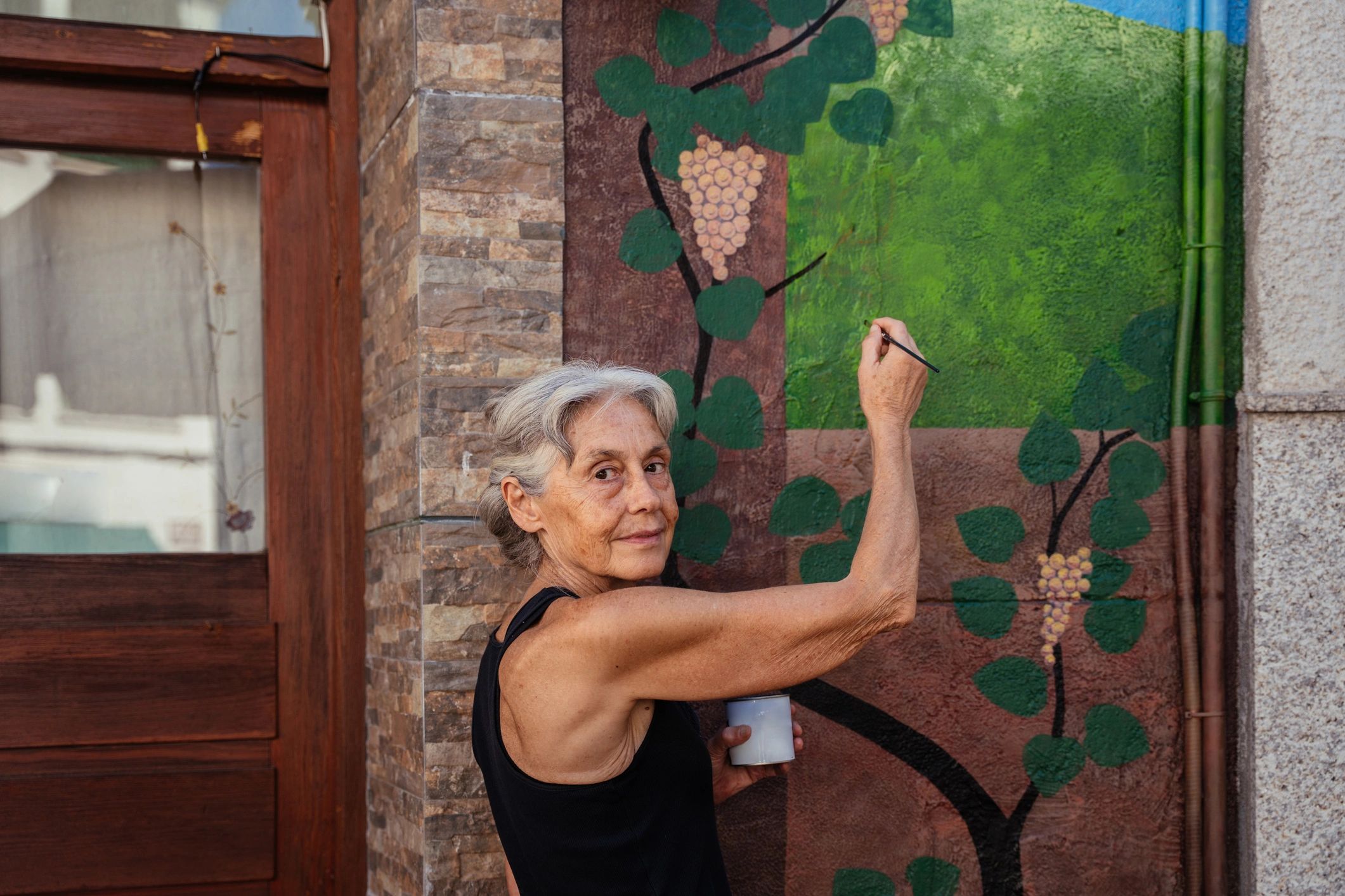 Artist painting decorative mural outdoors